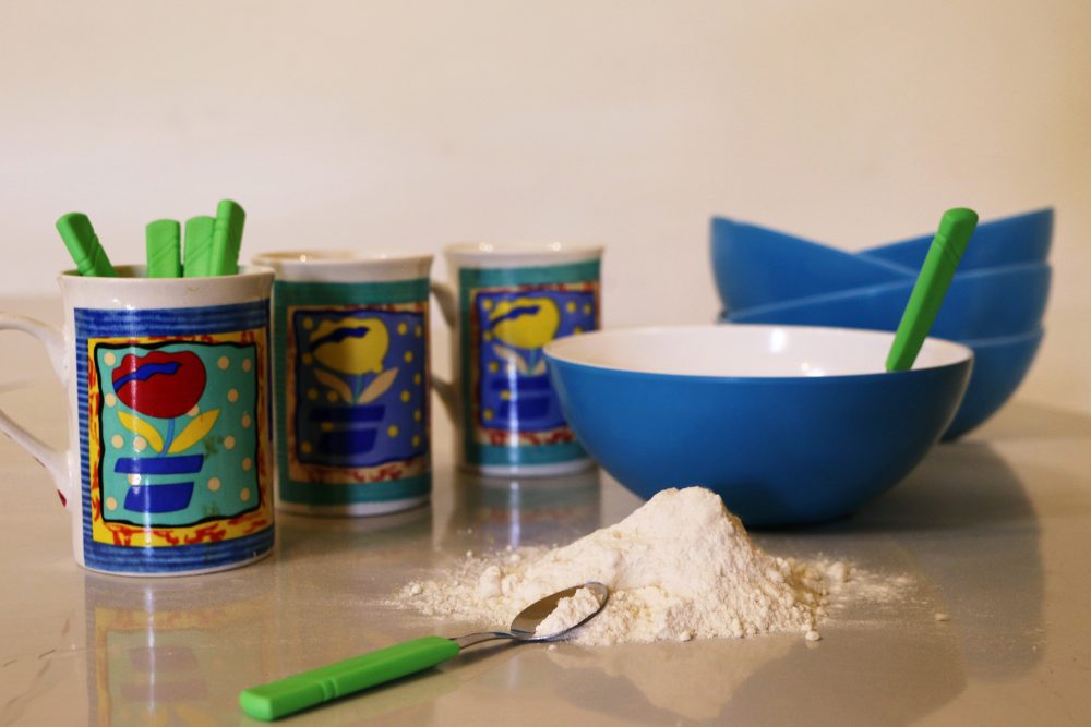 material usada na atividade: canecas, colheres, vasilhas e farinha sobre a mesa
