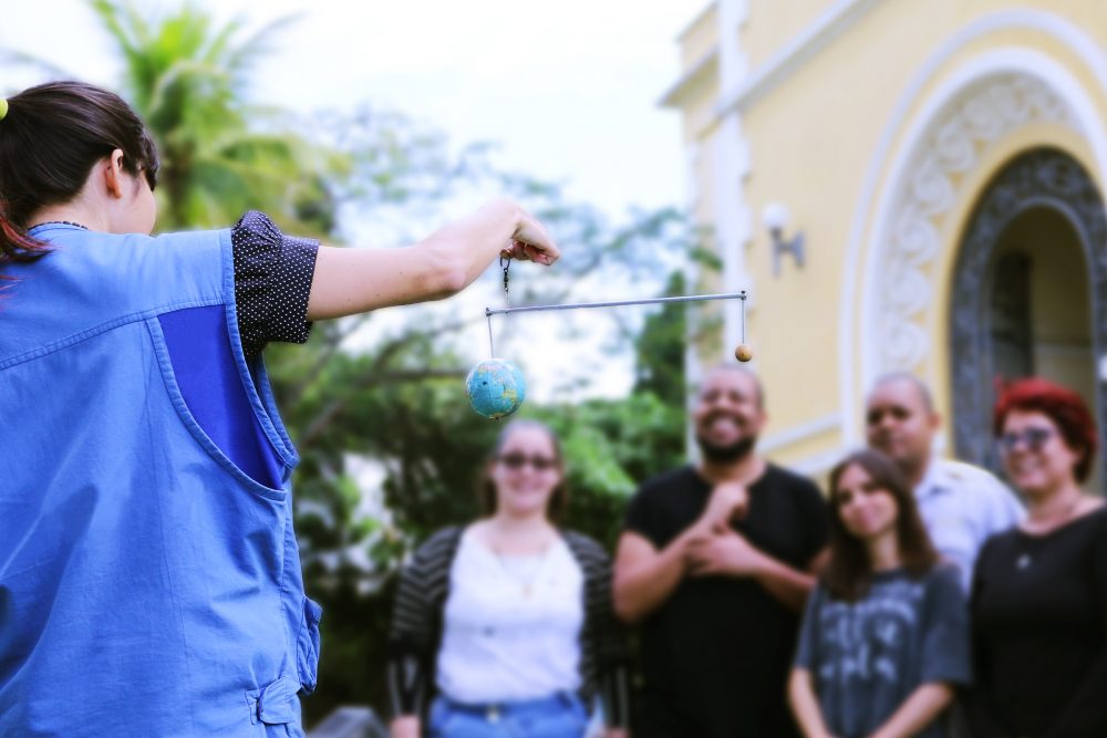 mediadora dando explicações a grupo de visitantes